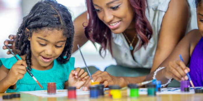 Une famille souriante fait du coschooling à la maison