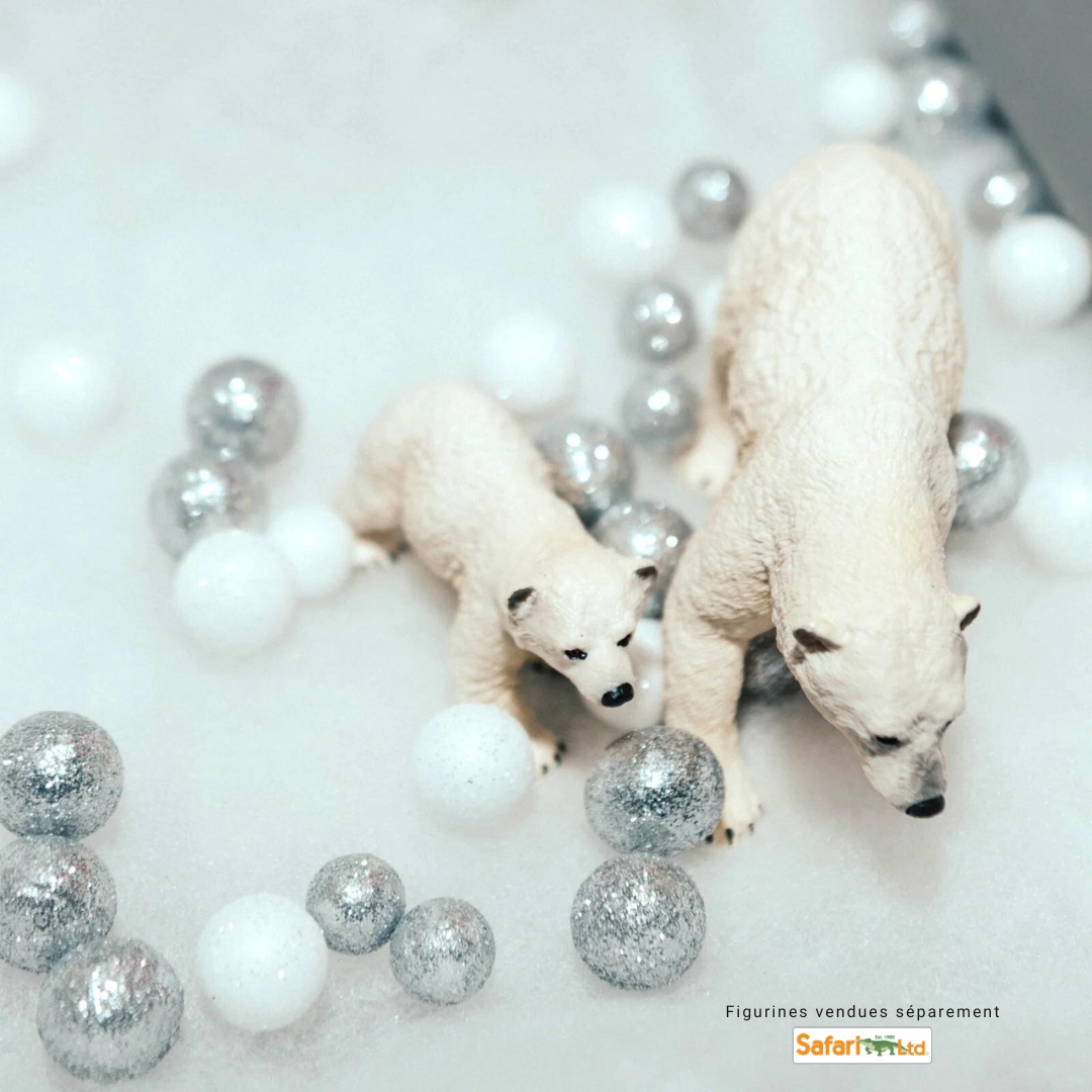 Deux figurines de jouet d’ours polaire sur un bac sensoriel rempli de ‘neige’, évoquant l’exploration de l’Antarctique.