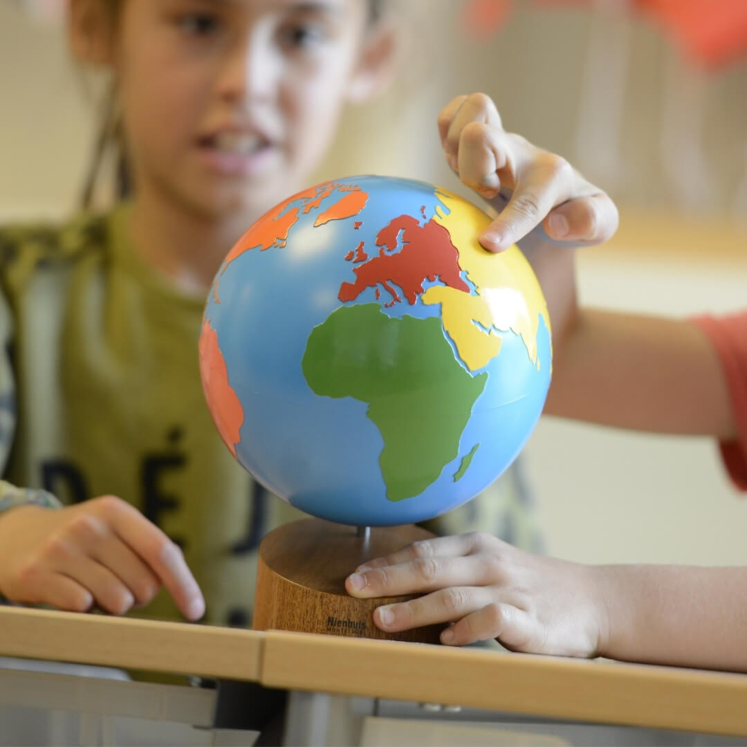 Globe des continents colorés : chaque couleur une nouvelle leçon de géographie dans la méthode Montessori.